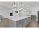 An open kitchen with a large center island, white countertops, modern lighting, and stainless steel appliances at 1238 Homecoming Blvd Blvd, Ravenel, SC 29470