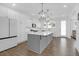 Bright, white kitchen with a large island, modern pendant lighting, and stainless steel appliances at 1238 Homecoming Blvd Blvd, Ravenel, SC 29470