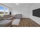 Living room with a comfortable sectional sofa, large windows, wood floors, and a modern entertainment system at 1238 Homecoming Blvd Blvd, Ravenel, SC 29470