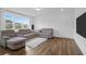 Bright living room with a sectional sofa, large windows offering neighborhood views, and wood flooring at 1238 Homecoming Blvd Blvd, Ravenel, SC 29470