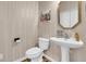 Traditional half bath with pedestal sink, patterned wallpaper, and framed art on display at 1325 Moss Path, Mount Pleasant, SC 29464
