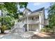 Angle view of the stilted home with a double porch, staircase, and a two-car garage at 1325 Moss Path, Mount Pleasant, SC 29464