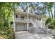 Side angle of the home with a porch, staircase, and a garage under the elevated structure at 1325 Moss Path, Mount Pleasant, SC 29464