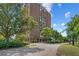 Brick high-rise building with manicured landscaping and mature trees on a sunny day at 14 Lockwood Dr # 1C, Charleston, SC 29401