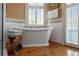 Bathroom boasts a soaking tub, hardwood floors, and plantation shutters for natural light at 15 Rutledge Ave, Charleston, SC 29401