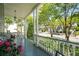 Inviting front porch with white columns, porch swing, and blooming flowers at 15 Rutledge Ave, Charleston, SC 29401