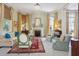 Bright, elegant living room with a fireplace, chandelier, and large windows with decorative drapes at 15 Rutledge Ave, Charleston, SC 29401