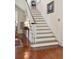 Traditional staircase design with white railing, hardwood floors, and landing table at 15 Rutledge Ave, Charleston, SC 29401