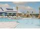 View of community pool featuring palm trees, sun loungers, and shallow water area with fountains under a cloudy sky at 150 Midtown Ave, Summerville, SC 29486