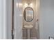 Stylish powder room features a pedestal sink, oval mirror, and modern lighting at 1589 Bluewater Way, Charleston, SC 29414