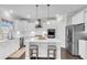 Modern kitchen features white cabinetry, stainless steel appliances, and a center island with seating at 185 Whaler Ave, Summerville, SC 29486