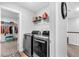 Modern laundry room with gray washer and dryer units, overhead shelving, and adjacent closet space at 185 Whaler Ave, Summerville, SC 29486