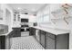 Bright kitchen with black cabinets, stainless steel appliances, marble counters, and decor tile floors at 1920 Iris St, North Charleston, SC 29405