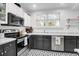 This kitchen boasts black and white cabinetry, stainless steel appliances, and tiled floors at 1920 Iris St, North Charleston, SC 29405