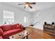 Cozy living room with hardwood floors, a red sofa, and an open staircase at 1920 Iris St, North Charleston, SC 29405