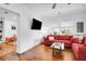 Bright living room with hardwood floors, a red sofa, and a TV at 1920 Iris St, North Charleston, SC 29405