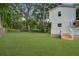 Lush green backyard showcasing the side of a home with a charming deck and stairs, surrounded by mature trees at 1986 Elaine St, Johns Island, SC 29455