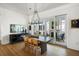 Bright dining room featuring a large wooden table, stylish chandelier, and sliding glass doors to the screened in patio at 2229 Boatwright Rd, Johns Island, SC 29455