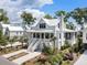 Stunning two-story white home featuring a charming porch, white metal roof and lush landscaping at 2229 Boatwright Rd, Johns Island, SC 29455