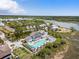 Aerial view of a luxurious pool and outdoor lounge area overlooking a serene waterway and lush green surroundings at 2229 Boatwright Rd, Johns Island, SC 29455