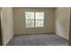 A clean bedroom with gray carpet and a bright window overlooking trees and nature at 2302 Scarlett Maple St, Summerville, SC 29486