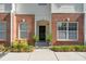 Close up of charming townhouse entrance with brick facade, and manicured landscaping at 241 Howle Ave # F, Charleston, SC 29412
