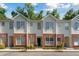 Charming townhouse featuring a brick facade, well-manicured landscaping, and multiple windows at 241 Howle Ave # F, Charleston, SC 29412