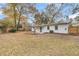 View of backyard and home with trees and a fence at 2462 Swallow Dr, Charleston, SC 29414