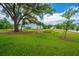 Spacious backyard with large tree, pond, and view of neighboring homes at 2596 Hatch Dr, Johns Island, SC 29455