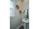 Half bath features pedestal sink, decorative wall hangings, wood look floors and natural light at 2596 Hatch Dr, Johns Island, SC 29455