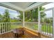 Screened porch with a live edge wood table and views of the surrounding lush greenery at 2596 Hatch Dr, Johns Island, SC 29455