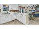 Bright kitchen featuring white cabinetry, peninsula, and stainless steel dishwasher with easy access to dining area at 3 Birmingham Ct, Charleston, SC 29407