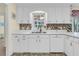 Bright kitchen with white cabinets, mosaic backsplash, stainless steel sink, and modern appliances at 3 Birmingham Ct, Charleston, SC 29407