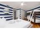 Bedroom featuring one bunkbed, ceiling fan, and striped walls for a nautical feel at 3009 Palm Blvd, Isle of Palms, SC 29451