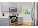 Well-lit kitchen featuring gray cabinets, stainless steel appliances and hardwood flooring at 3009 Palm Blvd, Isle of Palms, SC 29451