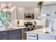 Bright kitchen with gray cabinets, stainless steel appliances, quartz counters and modern lighting at 3009 Palm Blvd, Isle of Palms, SC 29451
