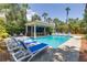 Lounge by the serene backyard pool, nestled among the palm trees, with ample seating and a covered outdoor kitchen at 3009 Palm Blvd, Isle of Palms, SC 29451