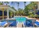 Inviting backyard pool with lush landscaping, lounge chairs, and covered bar area for outdoor entertaining and relaxation at 3009 Palm Blvd, Isle of Palms, SC 29451