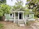 Charming green cottage with inviting front porch and well-maintained landscaping at 307 Mill St, Walterboro, SC 29488