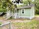 Quaint cottage featuring a fenced yard, classic window frames, and mature trees at 307 Mill St, Walterboro, SC 29488