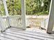 Covered porch with white railings and a view of a green and shady front yard at 307 Mill St, Walterboro, SC 29488