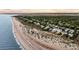 Aerial view of a beachfront community with homes nestled amongst lush trees along the shore with expansive sandy beach at 3128 Palmetto Blvd, Edisto Island, SC 29438