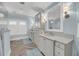 Well-lit bathroom featuring modern fixtures, double sinks, and wood look flooring at 3128 Palmetto Blvd, Edisto Island, SC 29438