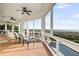 Screened-in covered deck with ceiling fans, comfortable seating, and panoramic ocean views at 3128 Palmetto Blvd, Edisto Island, SC 29438