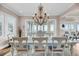 Bright dining room featuring a decorative chandelier, seating for eight, and sliding glass doors with water views at 3128 Palmetto Blvd, Edisto Island, SC 29438