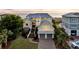 Stately beachfront home with a grand entrance, gray metal roof, two-car garage, and ample parking on a brick driveway at 3128 Palmetto Blvd, Edisto Island, SC 29438