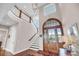 Grand foyer with a curved staircase, high ceilings, and a stunning wooden front door at 3128 Palmetto Blvd, Edisto Island, SC 29438