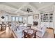 Open living room featuring a fireplace, custom built-ins, and glass doors with water views at 3128 Palmetto Blvd, Edisto Island, SC 29438