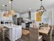 Well-lit kitchen with white cabinets, stainless steel appliances, island seating, and adjacent dining area at 3381 Stockdale St, Mount Pleasant, SC 29466