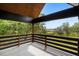 Inviting covered balcony with wood railings and views of lush greenery and a marsh landscape at 3399 Freeman Hill Rd, Johns Island, SC 29455